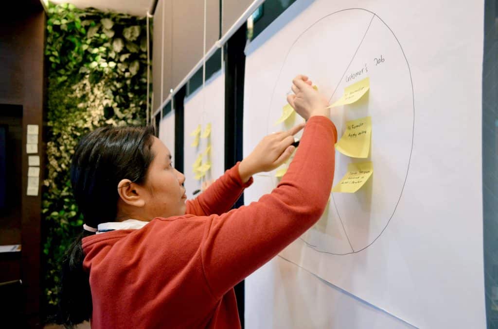 Woman pinning sticky notes on a board